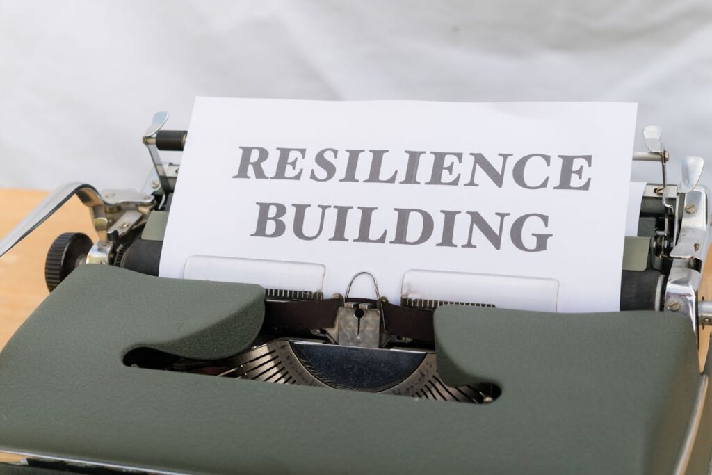 A typewriter with the word resilience building on it